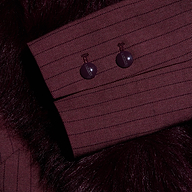 A close-up of a Sheila Blazer burgundy pinstripe sleeve cuff with two matching buttons against a dark, faux fur collar.