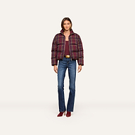 A woman stands facing forward against a plain light background, wearing the Larsa Oversized Puffer Jacket over a maroon top, blue jeans, and maroon shoes.