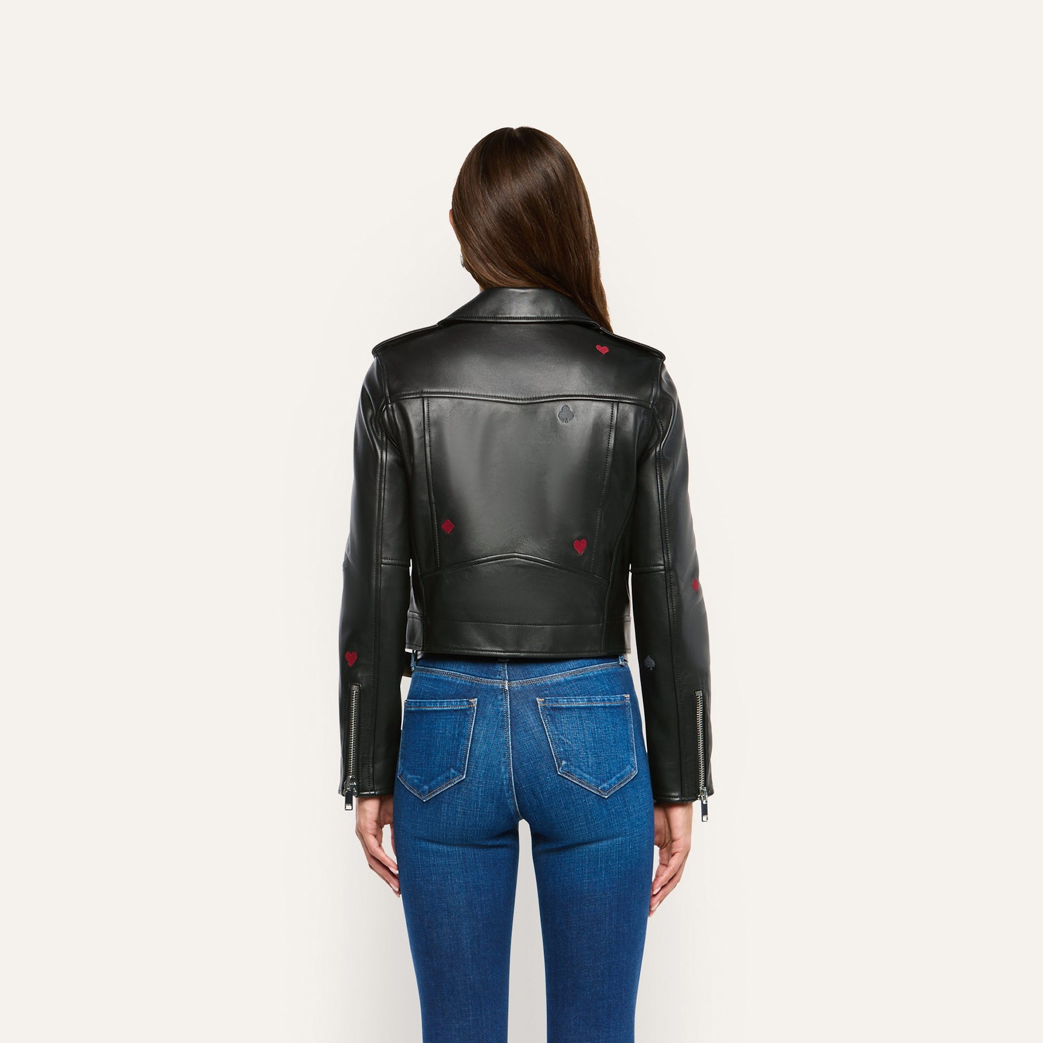 Back view of a person wearing a Blakely Embroidered Leather Jacket in black lambskin with small heart and spade icons, paired with blue jeans.