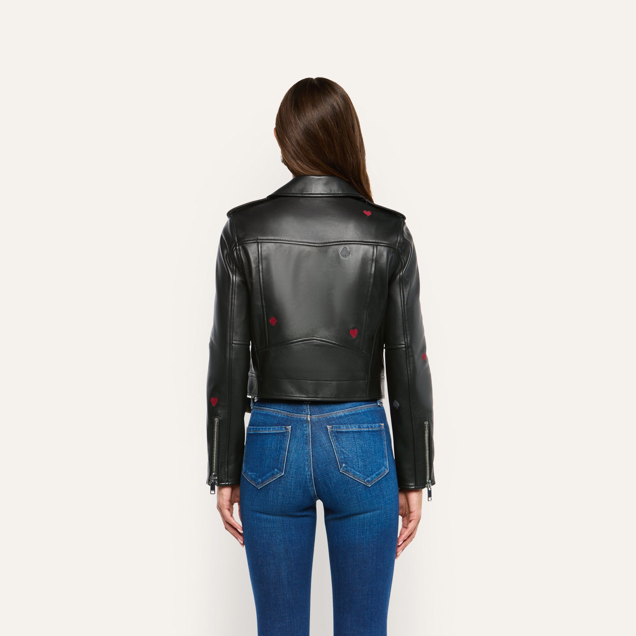 Back view of a person wearing a Blakely Embroidered Leather Jacket in black lambskin with small heart and spade icons, paired with blue jeans.