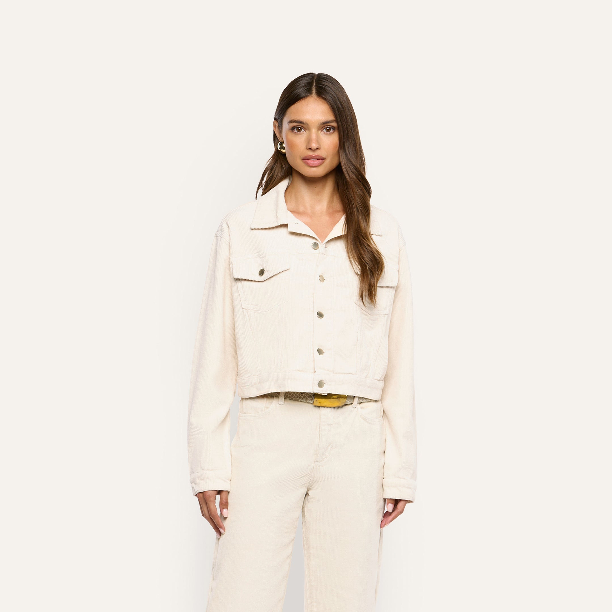A woman wearing an Alessia Corduroy Jacket in pearl white and matching trousers.