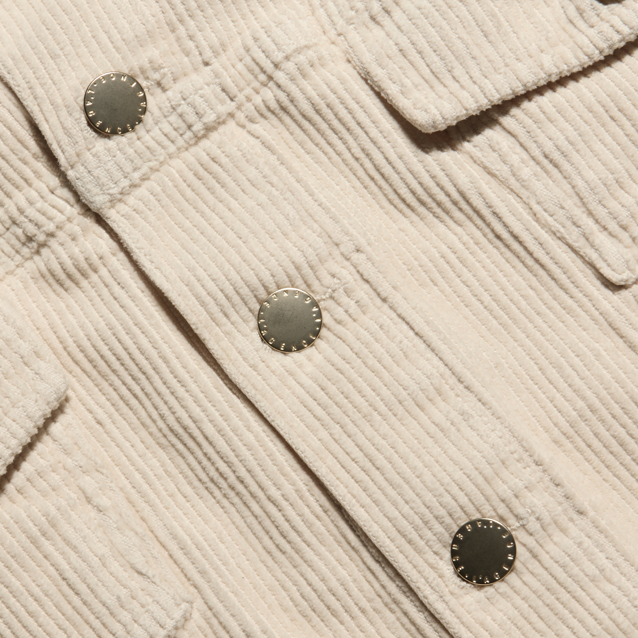 Close-up of a cropped pearl white Alessia Corduroy Jacket with a stretch corduroy texture and metal buttons.