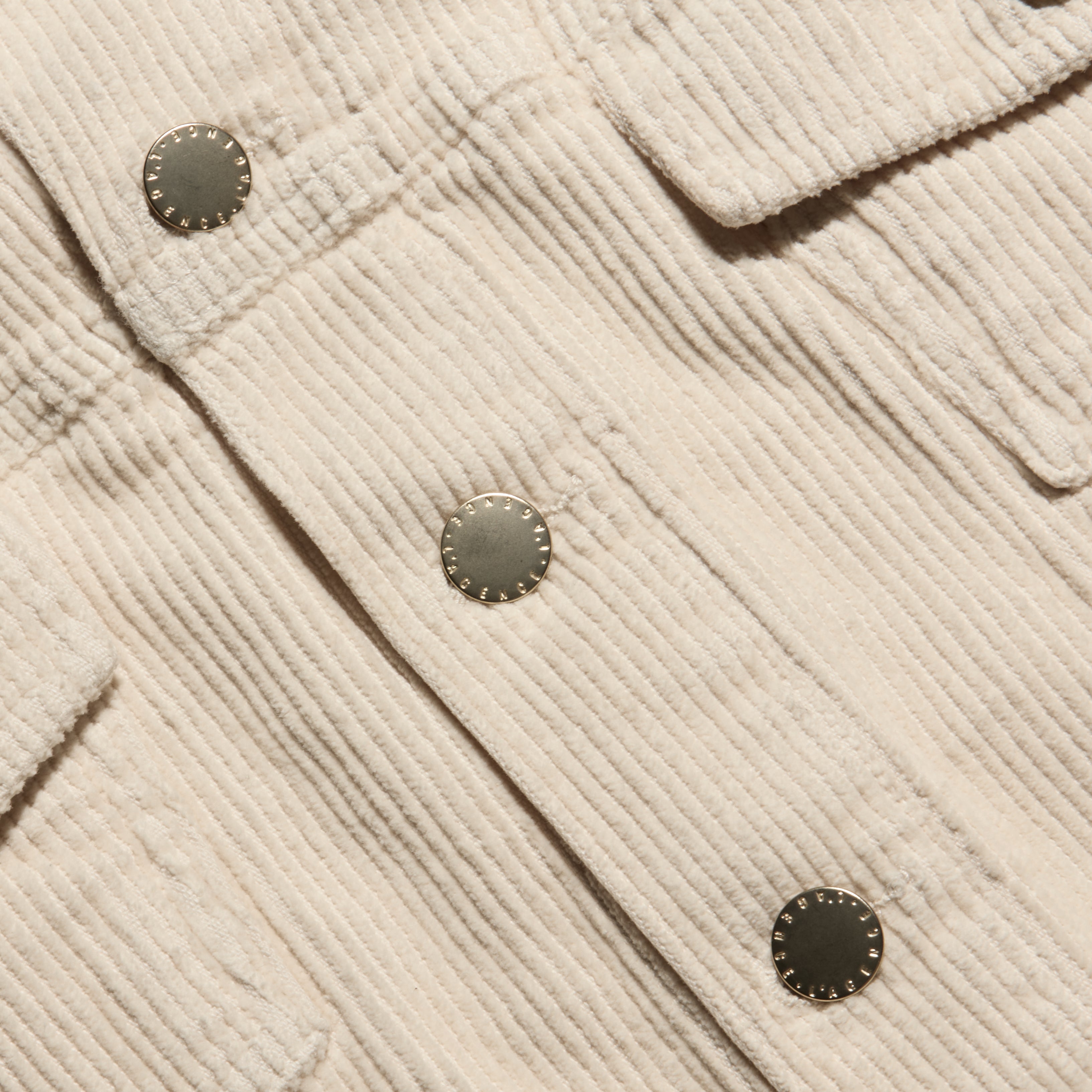 Close-up of a cropped pearl white Alessia Corduroy Jacket with a stretch corduroy texture and metal buttons.