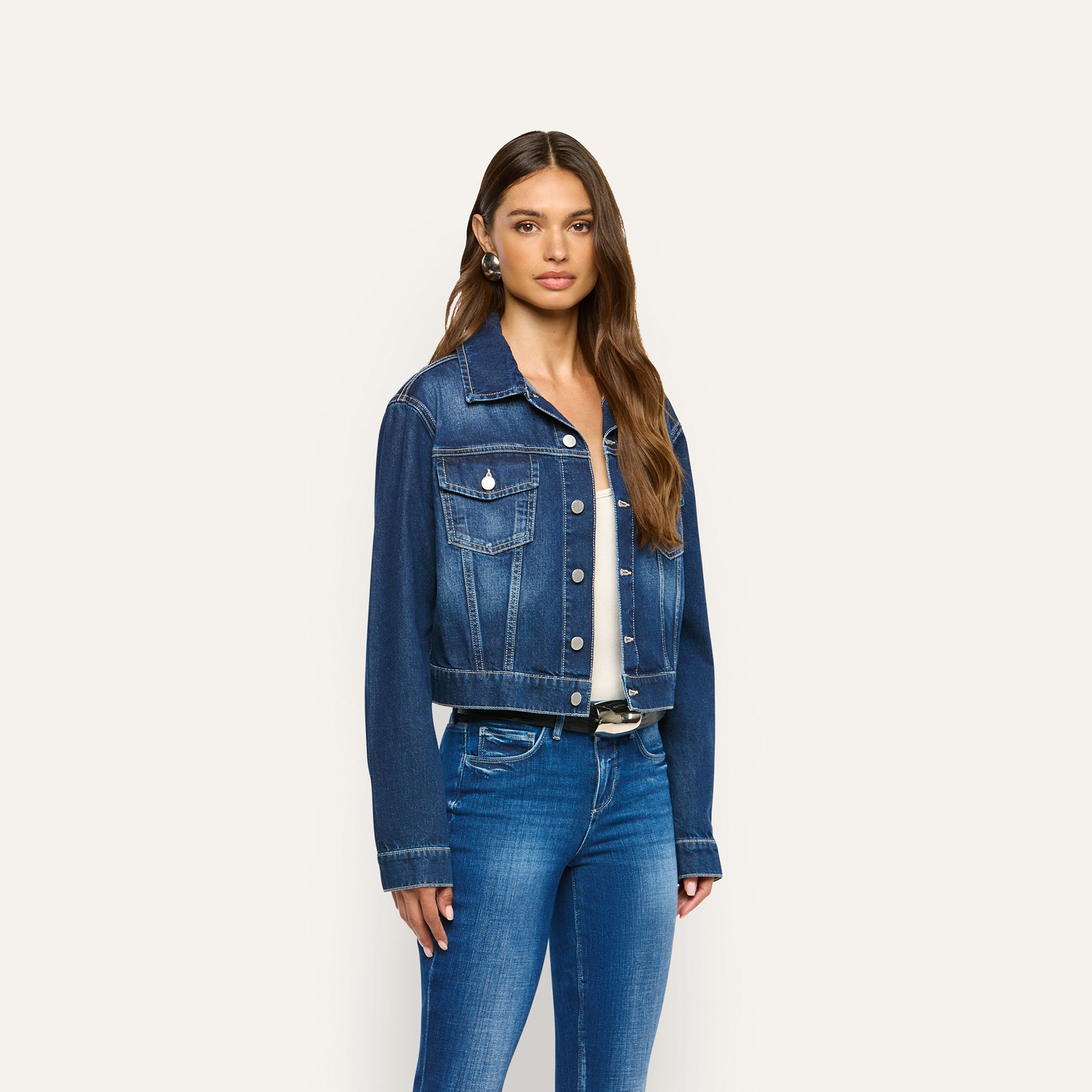 Alessia wearing a dark blue cropped Alessia Jean Jacket over a white top and blue jeans.