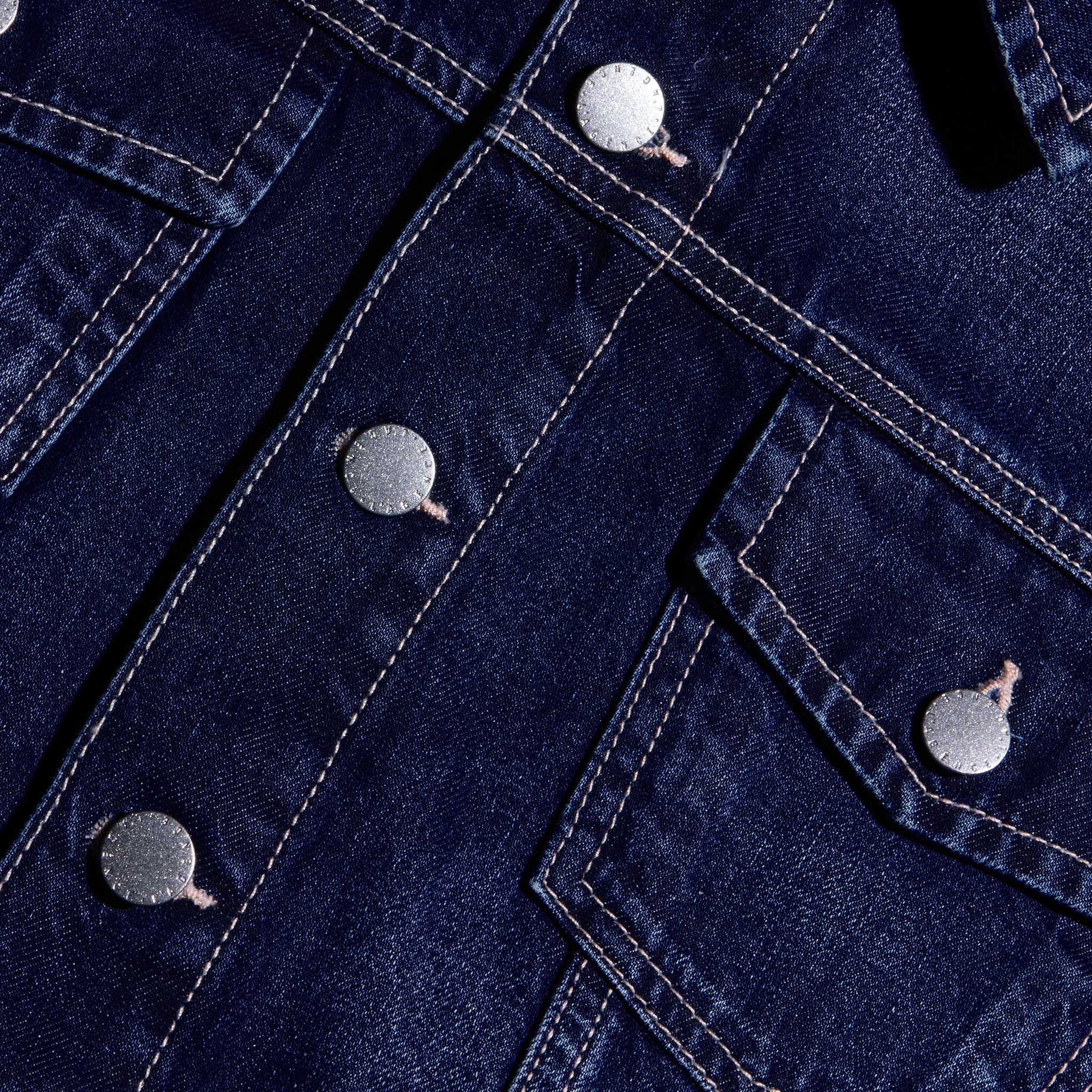 Close-up of the Alessia Jean Jacket in dark denim, featuring silver-tone metal buttons and contrast stitching.