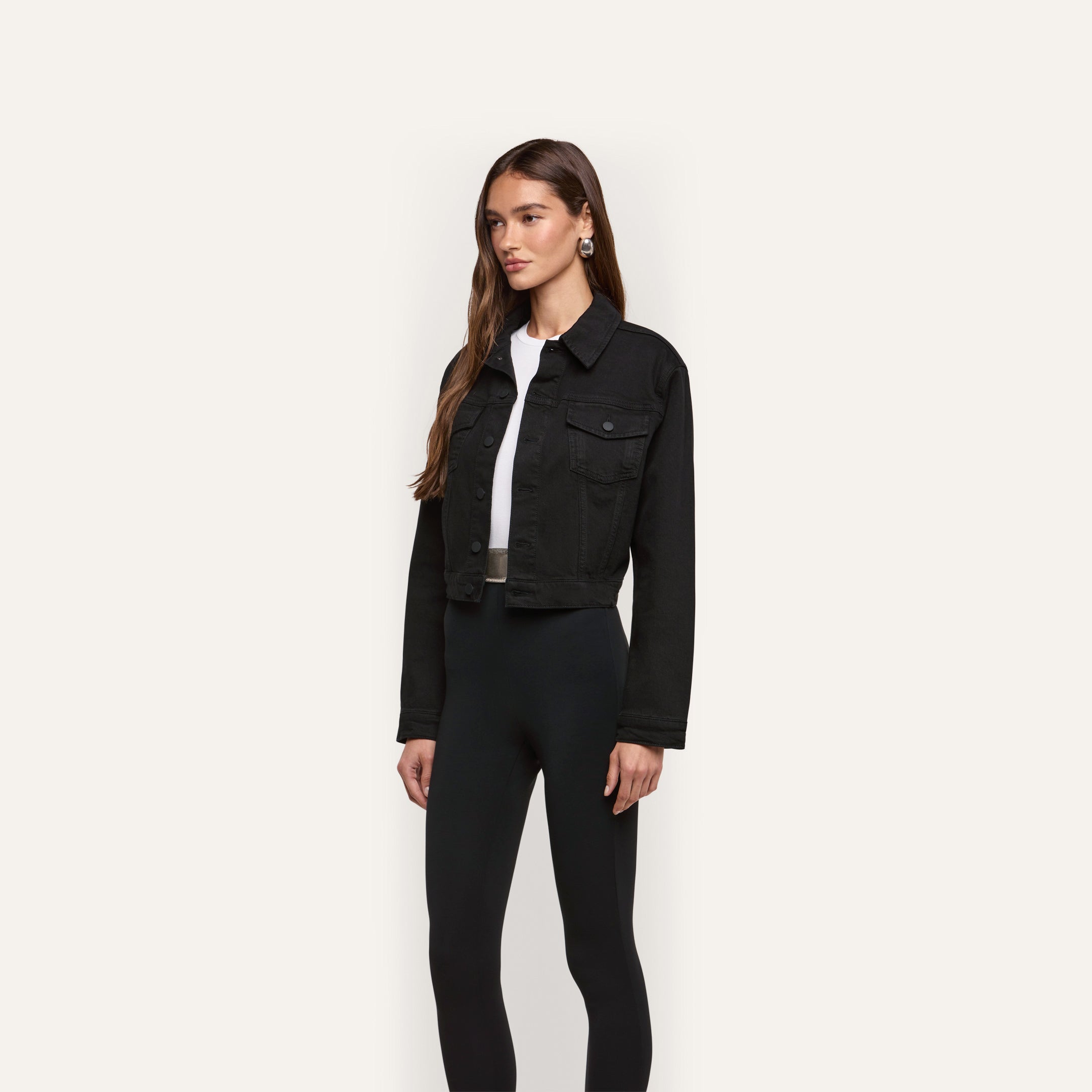 A model wears an Alessia Jean Jacket cropped in black over a white t-shirt and black leggings.