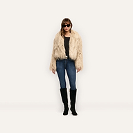 A woman wears a Fenella Faux Fur Coat over a black shirt, blue jeans, and black knee-high boots.