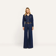 A person wearing an Edin Jean Jacket in indigo wash with gold buttons and matching wide-leg high-waisted jeans.