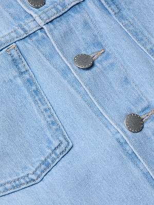 Close-up of light wash denim fabric on the slim fit Celine Jean Jacket, showcasing a front pocket, three silver metal buttons, and visible stitching details.