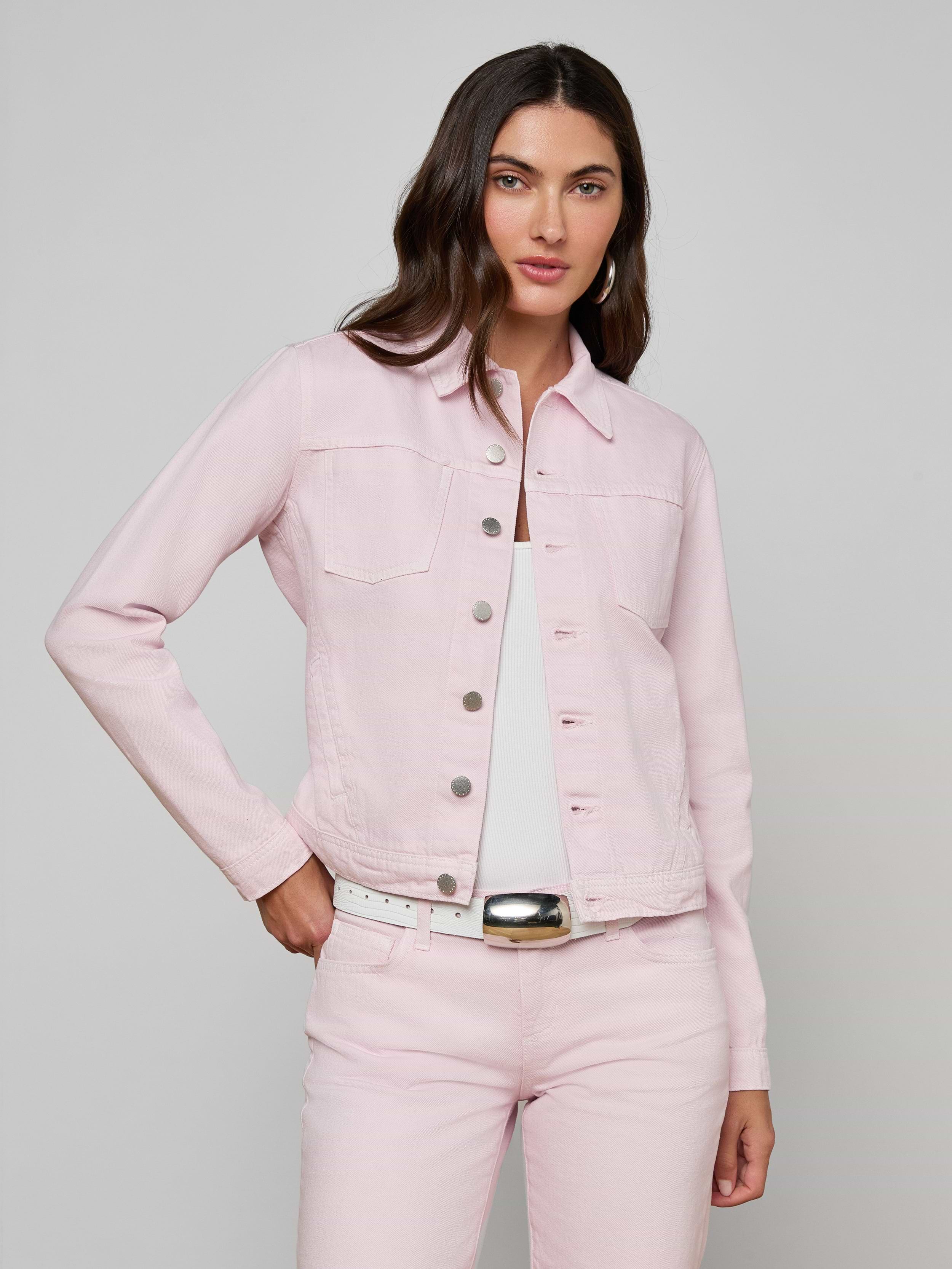 A woman wearing the Celine Jean Jacket in pastel lilac, styled in a slim fit, pairs it with matching pink jeans. She stands with one hand in her pocket and looks confidently at the camera against an off-white, plain background.