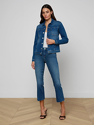 A woman stands against a white background wearing the Celine Jean Jacket in a vintage wash, matching slim fit blue jeans, and black heeled sandals.