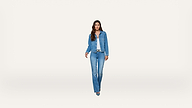 A woman stands facing forward, wearing a blue denim jacket, blue jeans, a white shirt, and blue shoes, against a plain white background.