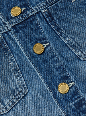 Close-up of the L’AGENCE Celine Jean Jacket in classic denim blue, featuring a slim fit, three embossed brass buttons, and prominent stitching with detailed pocket seams for a stylish decorative touch.
