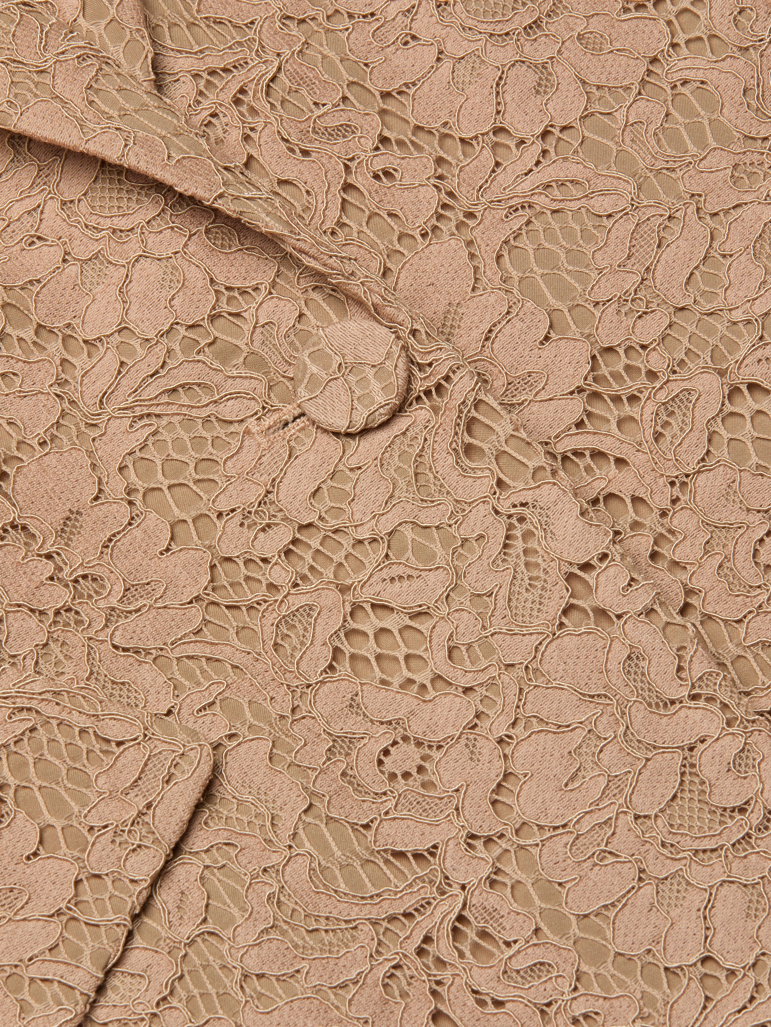 Close-up of the Chamberlain Lace Blazer in beige, showcasing intricate floral lace patterns and visible stitching that highlight the fabric’s texture and delicate details—perfect for achieving an office-ready style.