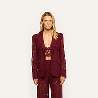 A woman wearing a Chamberlain Lace Blazer in deep port red, paired with a matching cropped lace bralette and lace trousers.