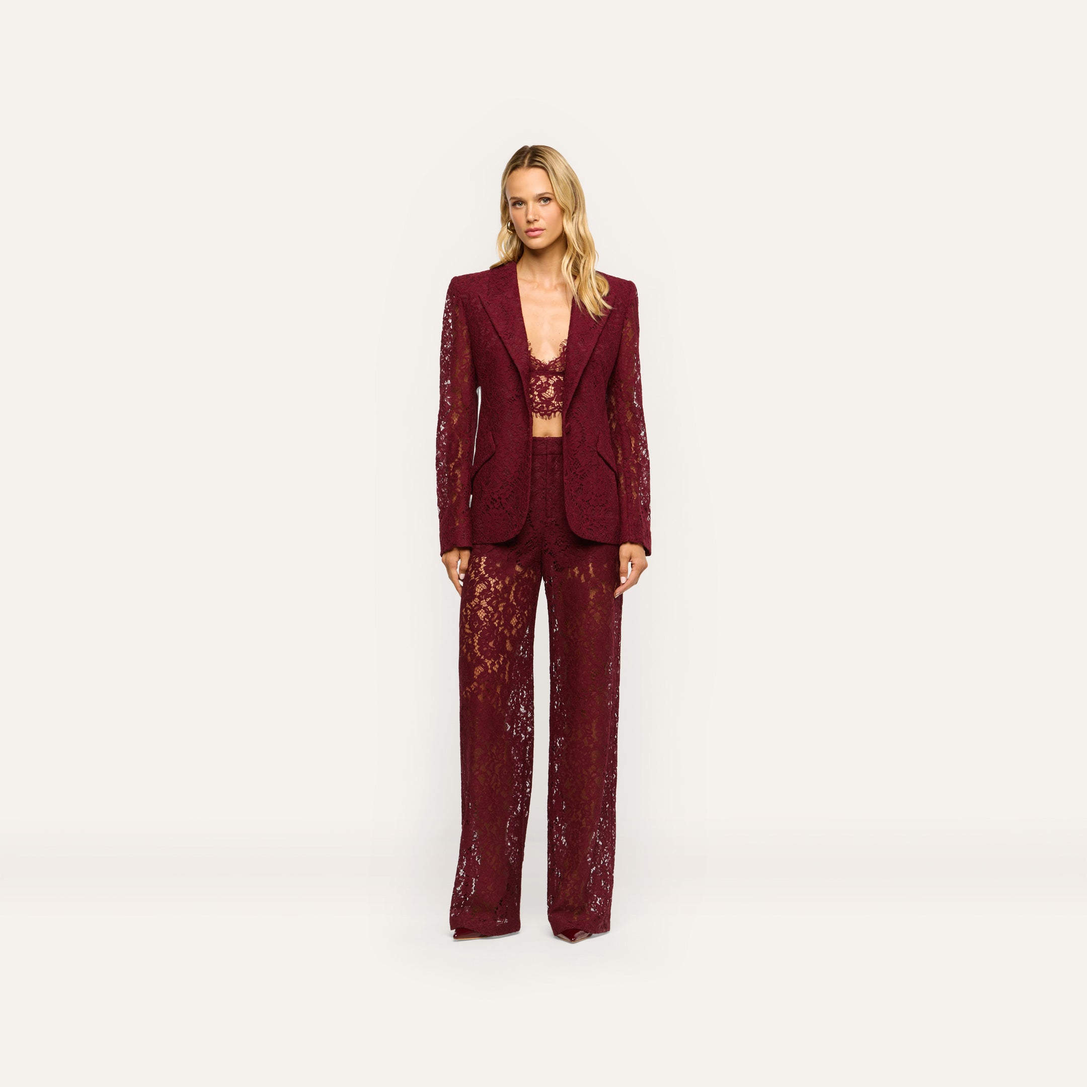 A model wears a matching deep port red Chamberlain Lace Blazer, crop top, and wide-leg trousers in a classic design.
