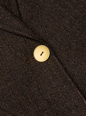 Close-up of the Chamberlain Pinstriped Blazer by L'AGENCE, featuring brown pinstripes, textured recycled wool-blend fabric, and a single gold-colored button.