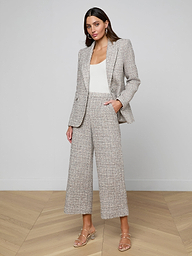 A woman stands against a plain light background wearing the Chamberlain Tweed Blazer in gray plaid, paired with matching wide-leg cropped pants, a white top, and beige heeled sandals.