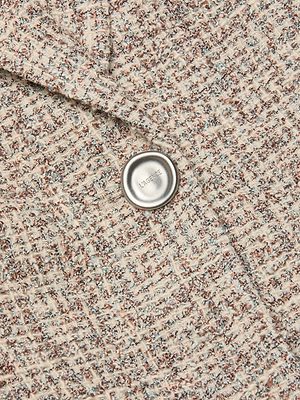 Close-up of the Chamberlain Tweed Blazers textured, woven dusty blue tweed fabric in cream, brown, and blue with a single silver MANGO-engraved button.