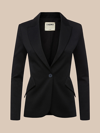 The Chamberlain Blazer, crafted from black twill suiting with a single button closure and notched lapels, is displayed against a beige background to highlight its refined, precision-tailoring finish.