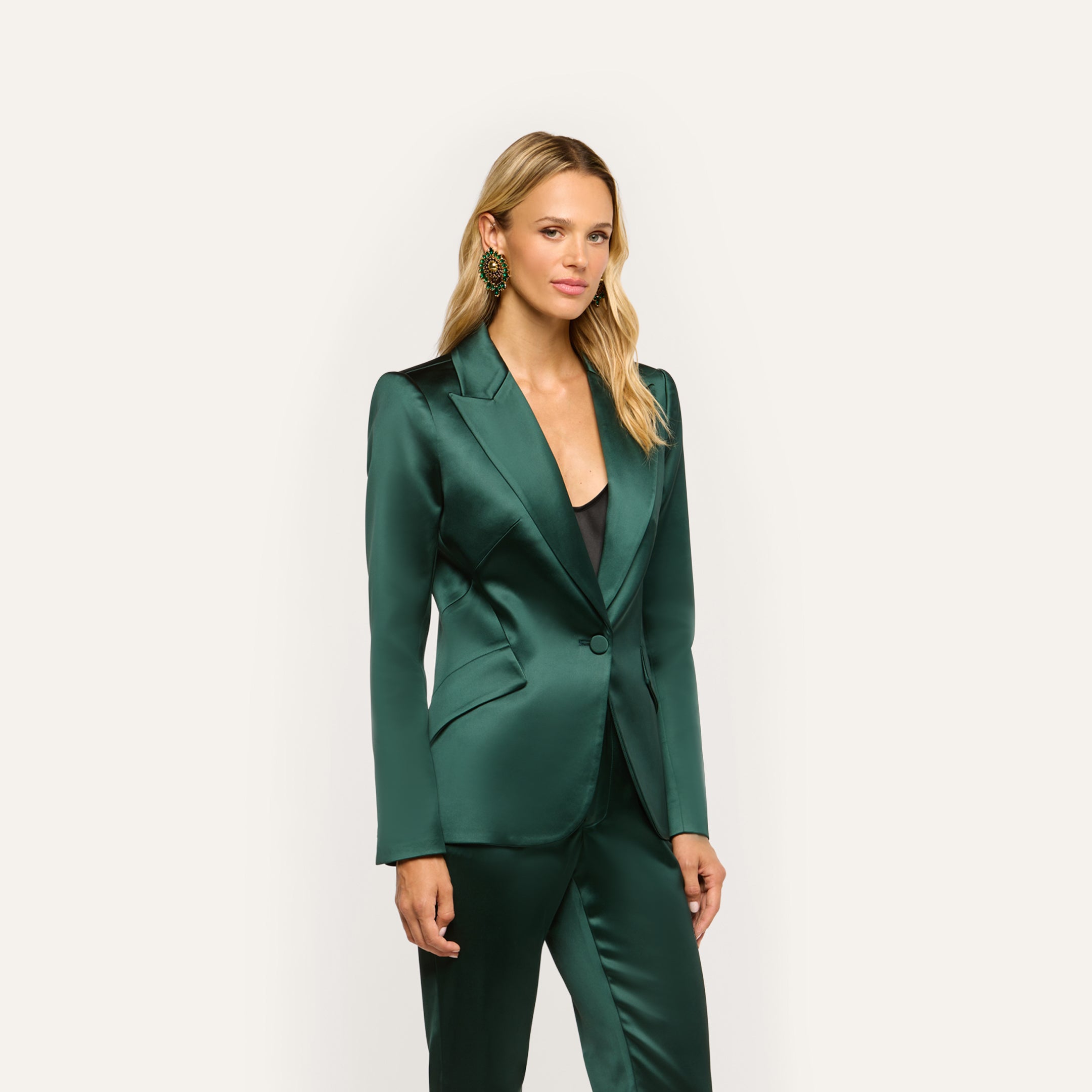 A woman wearing a forest green Chamberlain Satin Blazer and matching trousers.
