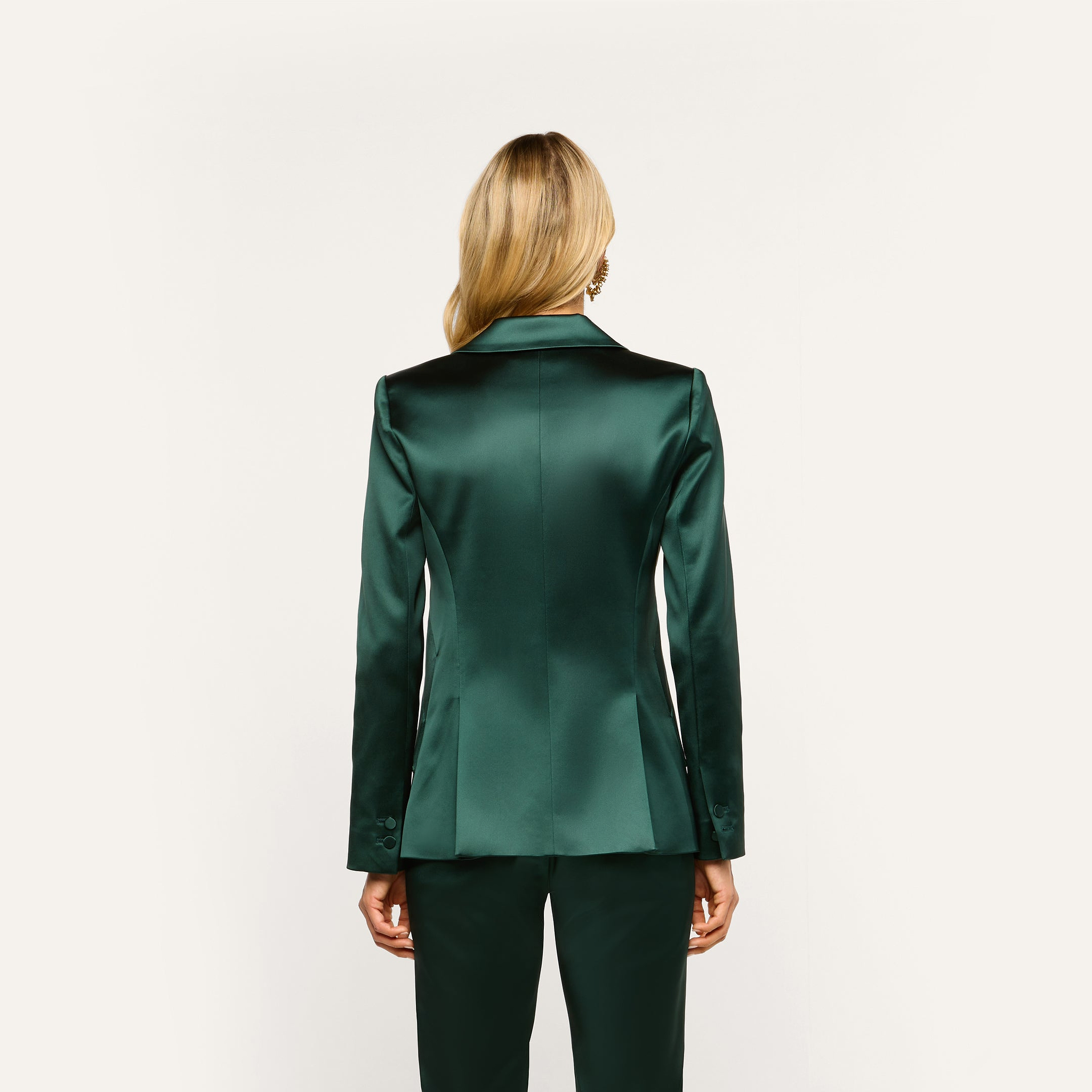 Back view of a person wearing a forest green Chamberlain Satin Blazer and matching trousers.
