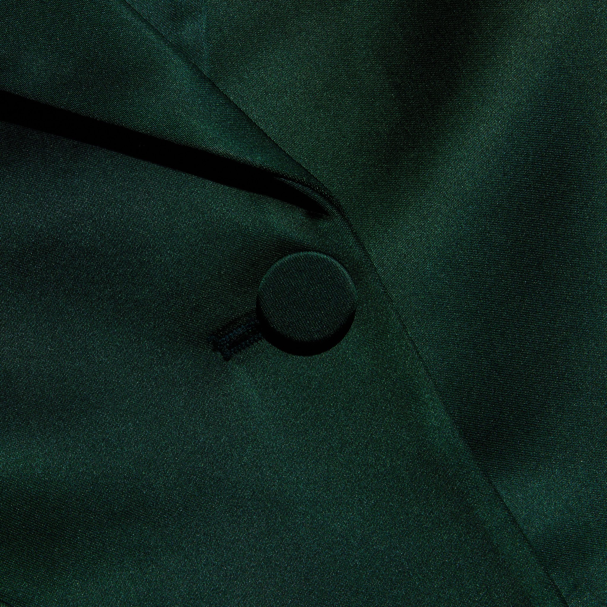 Close-up of a forest green Chamberlain Satin Blazer showing the fabric-covered button and lapel.