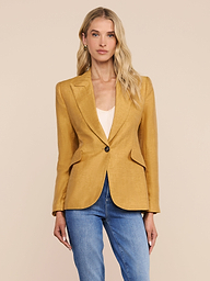A woman stands facing forward against a plain, light background, wearing the Chamberlain Linen-Blend Blazer in mustard yellow over a white top and blue jeans.