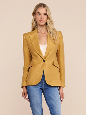 A woman with long blonde hair wears the Chamberlain Linen-Blend Blazer in gold over a white top and blue jeans, standing against a plain beige background.