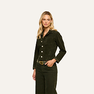 A woman with long blonde hair wears the Janelle Corduroy Jacket and matching pants, posing with one hand in her pocket against a plain light background.