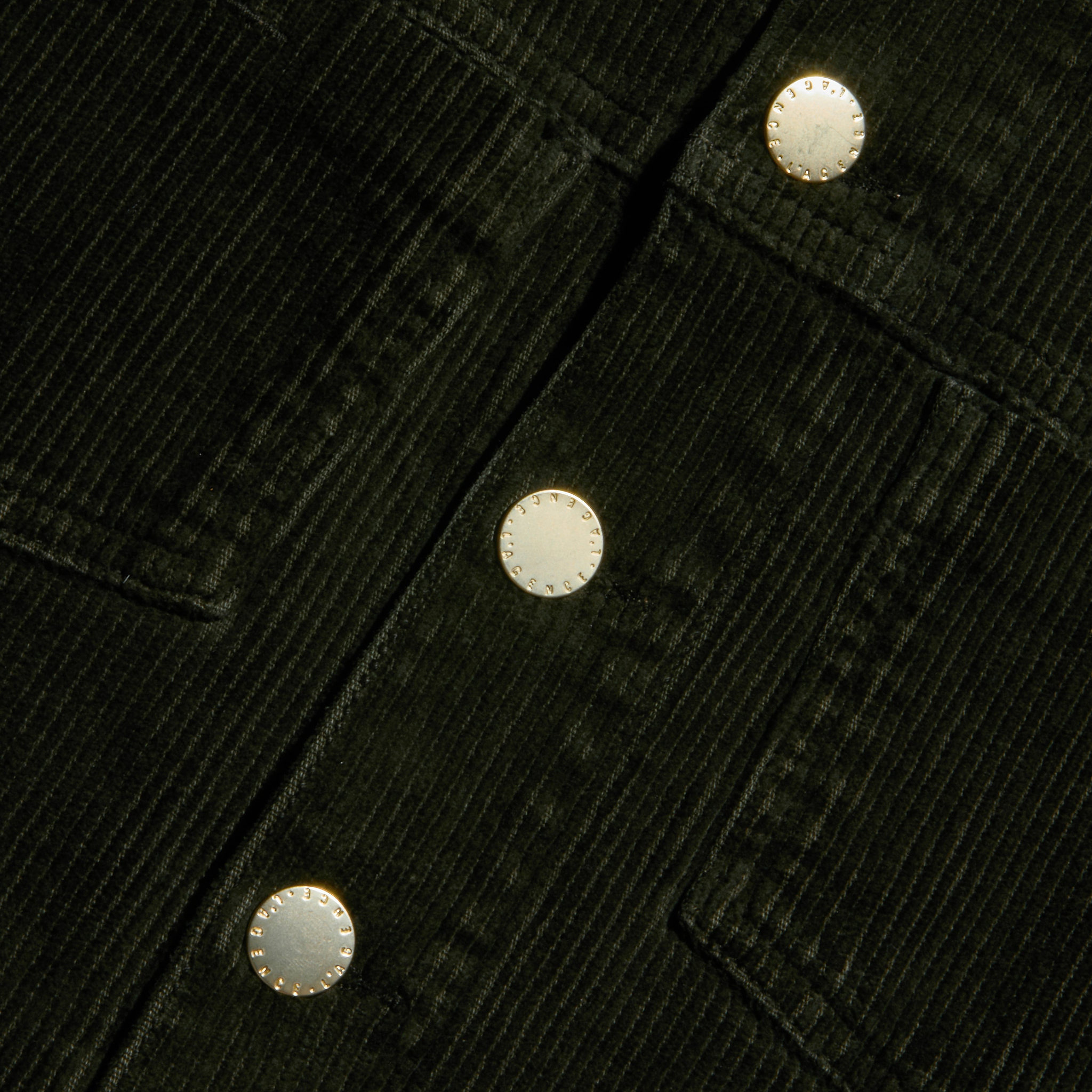 Close-up of the Janelle Corduroy Jacket in green, featuring three round metallic buttons and prominently stitched pocket seams.