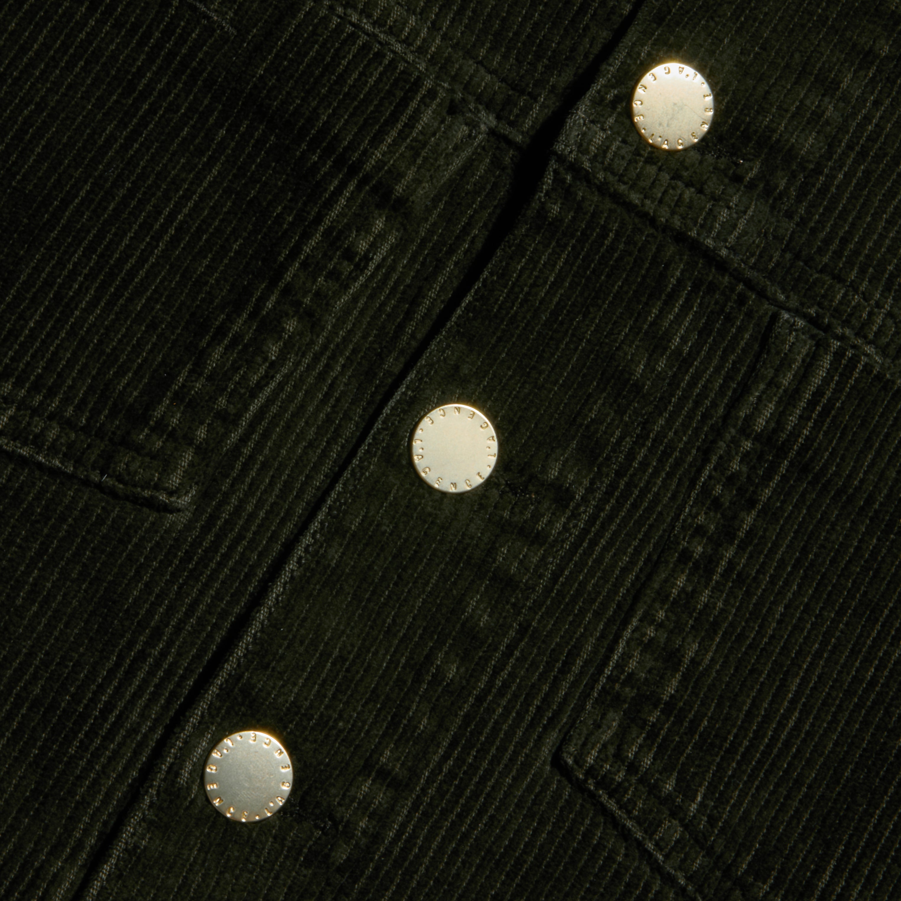 Close-up of the Janelle Corduroy Jacket in green, featuring three round metallic buttons and prominently stitched pocket seams.