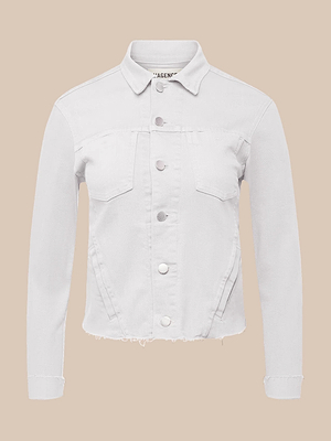 The Janelle Jean Jacket features long sleeves, a button-up front, two chest flap pockets, a slightly frayed hem, and a feminine fit in stretch white denim, displayed against a beige background.