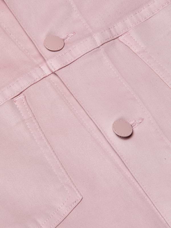 Close-up of the Janelle Coated Jean Jacket in light pink, featuring metal buttons and intersecting stitched seams that highlight the fabric’s textured structure.