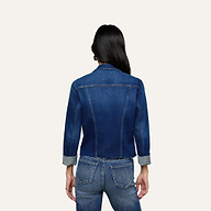 A person with long dark hair is shown from the back, wearing the Janelle Jean Jacket with rolled sleeves and matching blue denim jeans against a plain light background.