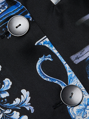 Close-up of the Colin Silk Blazer by L'AGENCE: black silk charmeuse with blue and white floral patterns, detailed with two large black round buttons sewn vertically.