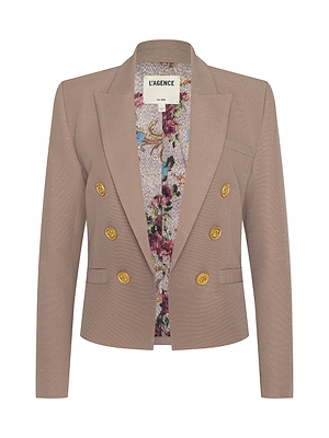 The Brooke Blazer is a taupe double-breasted jacket with gold buttons and a floral inner lining, made from lightweight ribbed fabric. Displayed on a white background, its collar label shows L’AGENCE.