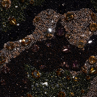 Close-up of the Jen Crystal Blazer’s couture-inspired embroidered fabric, embellished with sequins, shiny beads, and brown, gold, and dark gemstones arranged in an ornate abstract pattern.