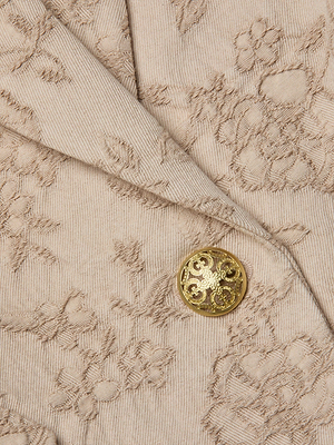 Close-up of the Jennah Jacquard Blazer by L'AGENCE Sale, featuring beige floral jacquard fabric with embroidered detail and a shiny gold button.