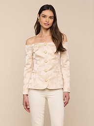 A woman wearing the Alice Blazer Top in cream-colored jacquard satin with gold buttons, paired with matching cream tailored suiting pants, stands against a plain light background.