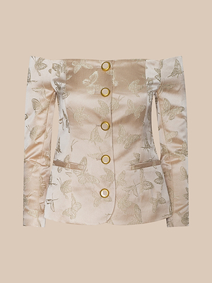 Das Alice Blazer Top, ein hellbeiger, schulterfreier Blazer aus Schmetterlings-Jacquard-Satin mit goldenen, runden Knöpfen, gerüschten, langen Ärmeln, Vordertaschen und goldenen Schmetterlingsmustern, ist auf einem einfarbig beigen Hintergrund abgebildet.