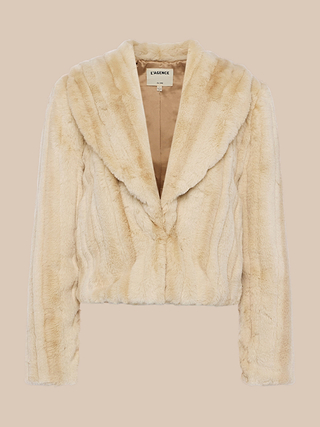 The Davy Faux Fur Jacket, in beige with a mink-inspired texture, showcases a wide lapel collar and long sleeves, displayed against a plain light background.