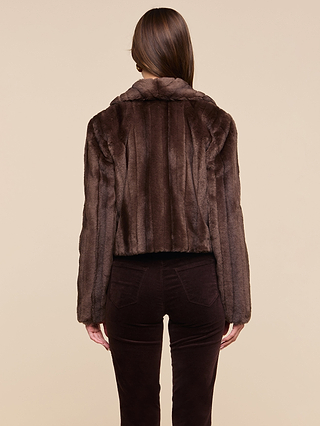 A person with long brown hair, shown from the back, stands against a plain beige background wearing the retro-inspired Davy Faux Fur Jacket paired with matching pants.