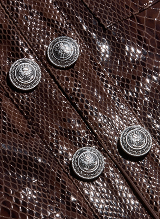 Close-up of the Jayde Leather Jacket in shiny brown snake print, showcasing four metallic buttons with embossed designs arranged in two parallel rows.