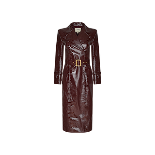 Introducing the Celina Trench Coat: a dark brown, long-sleeve vegan leather piece with striking crocodile embossing, a wide collar, and a matching belt featuring a rectangular buckle. Displayed on a plain white background, this faux-crocodile trench is an elevated statement inspired by Fall 2026 fashion.