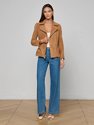 A woman stands facing forward wearing the Dinah Suede Biker Jacket from the women’s outerwear collection, a beige top, blue wide-leg jeans, and open-toe heels against a plain white background.
