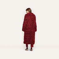 A person viewed from behind, wearing a deep red Lizbeth Faux Fur Jacket, matching trousers, and high-heeled pumps.