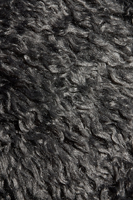 Close-up of the Lizbeth Faux Fur Jacket in dark gray, featuring curly, textured shag faux fur with wavy patterns and a lustrous surface that catches the light—evoking styles seen at New York Fashion Week.