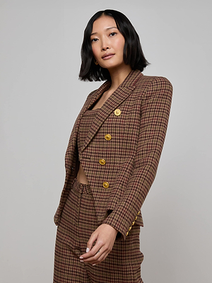 A woman with a bob haircut models the L'AGENCE Bethany Houndstooth Blazer with lion head buttons, posing against a plain light gray background.