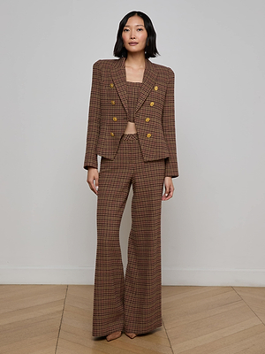 A woman with shoulder-length dark hair wears the L'AGENCE Bethany Houndstooth Blazer and matching wide-leg trousers over a beige top, standing against a plain background with a neutral expression.